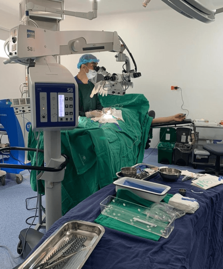 Ophthalmic surgeon using a Zeiss S88 microscope for a delicate procedure on a patient.